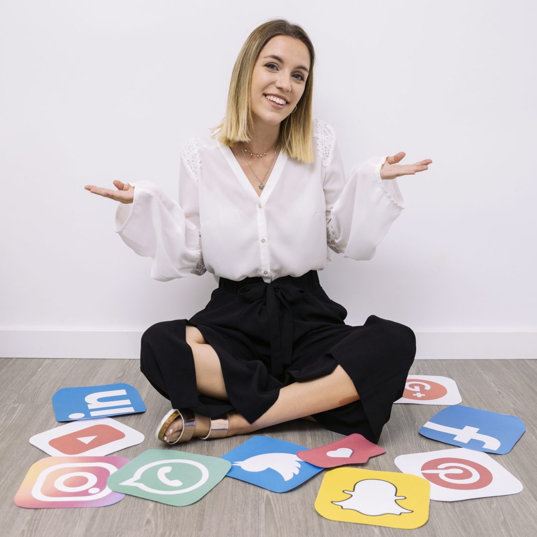 businesswoman-sitting-floor-with-social-media-icons-shrugging